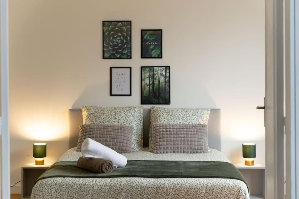 圣但尼Réconfort - 15 min de Paris的卧室配有一张墙上三幅照片的床