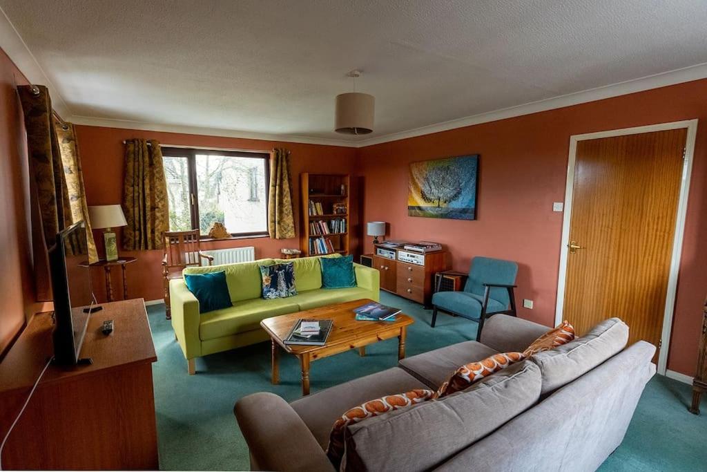 肯德尔UNDERWOOD COTTAGE - Peaceful House in Kendal with views of Cumbria的客厅配有沙发和桌子