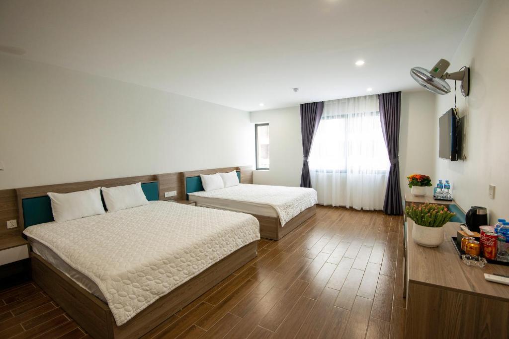 谅山ANH TU Hotel的酒店客房设有两张床和窗户。