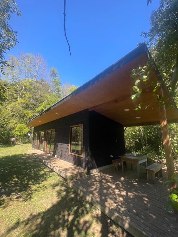 里坎雷Pucura Eco Lodge的前面有一张野餐桌的建筑