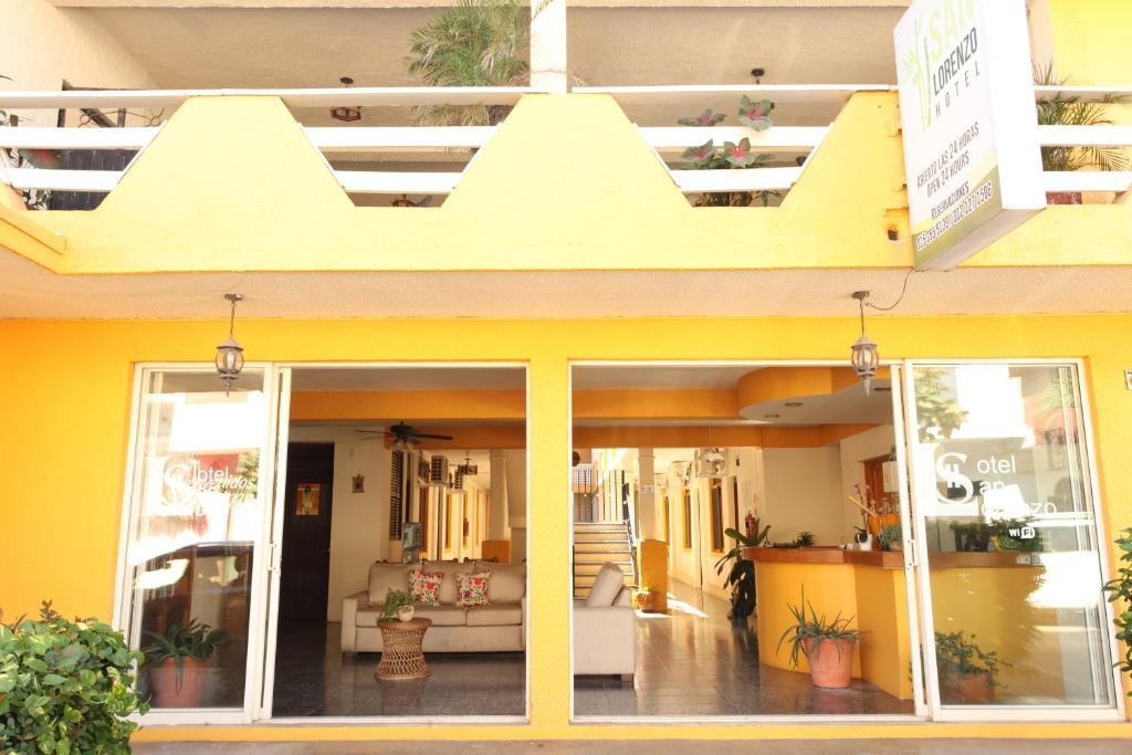 巴拉德纳维达Hotel San Lorenzo的商店前方是一座带阳台的黄色建筑
