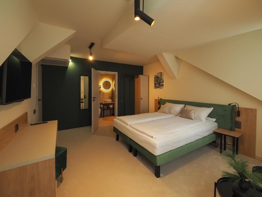 锡比乌Craft Inn - Boutique Hotel的一间卧室配有一张大床和绿色床头板