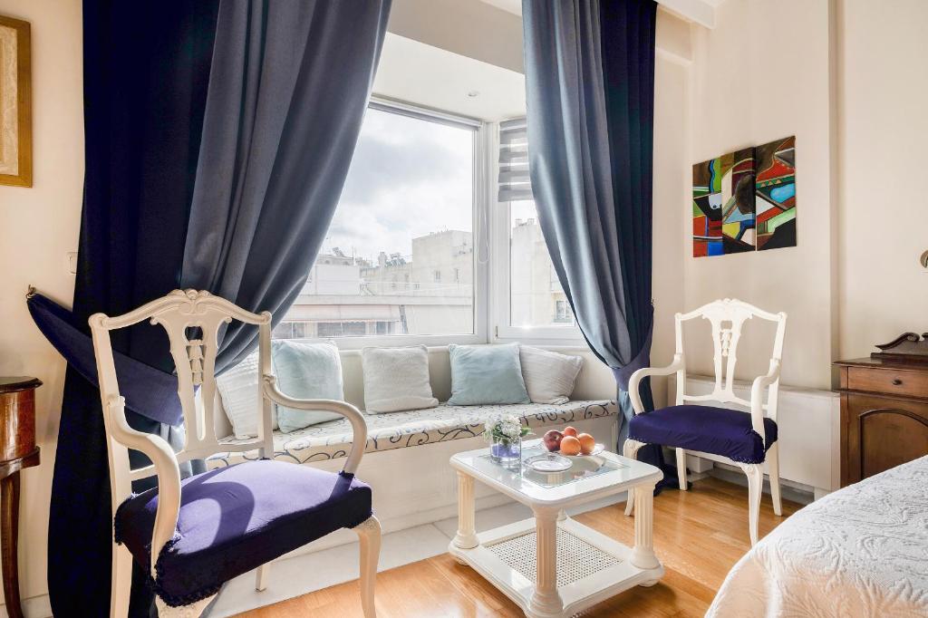 雅典艺术豪华别墅的客厅配有沙发、两把椅子和窗户