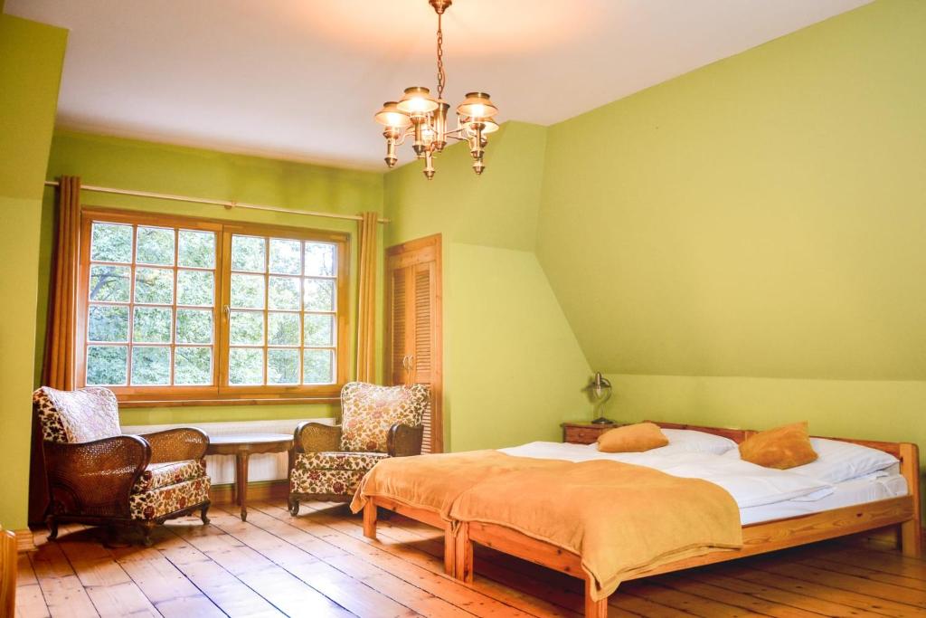 ZachełmieRezydencja Lawendowe Wzgórze的一间卧室配有一张床、两把椅子和一个窗户