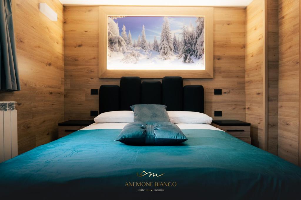 帕苏德尔托纳莱Anemone Bianco Suite Rooms的卧室配有一张挂在墙上的床铺