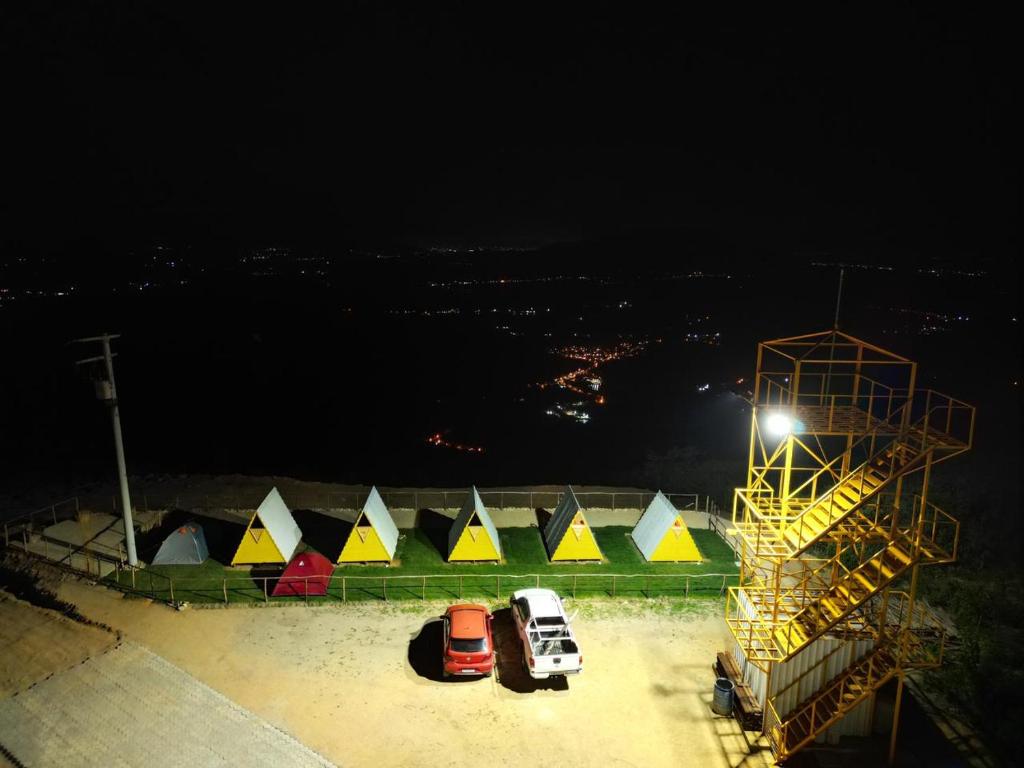 A Chave da Montanha的一群帐篷和汽车在晚上停在停车场