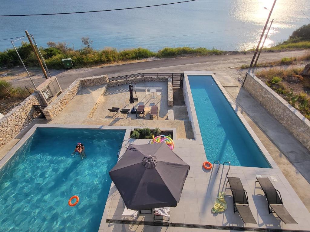 帕莱罗斯Ionian Sea Villas的游泳池顶部景,带遮阳伞