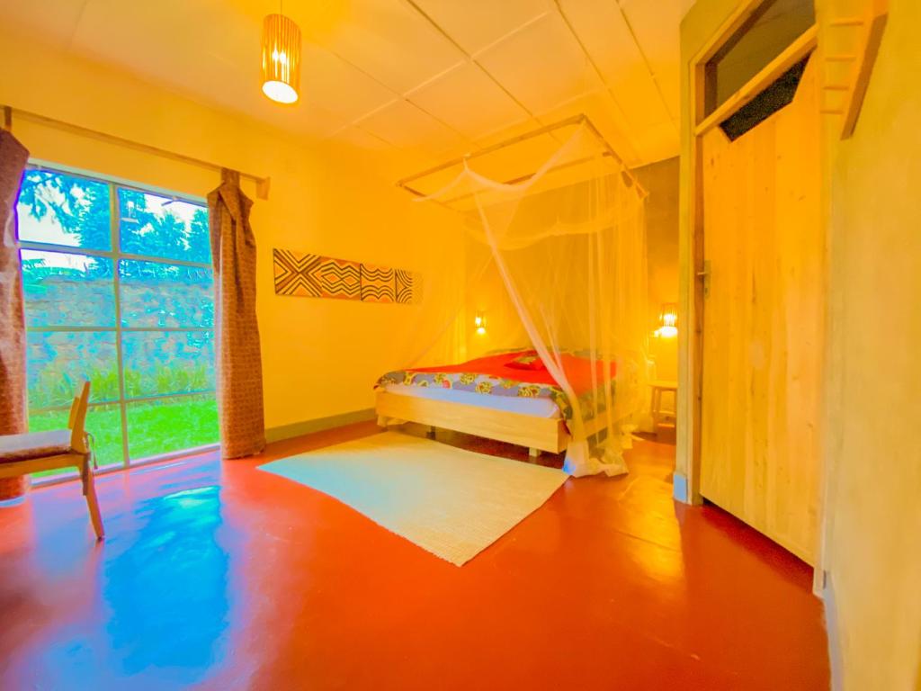 RuhengeriRoom in Guest room - Isange Paradise Resort的一间卧室配有一张带蚊帐的床