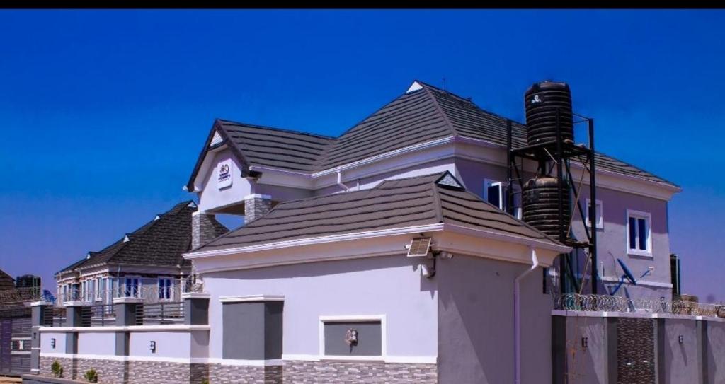 伊巴丹D'EXQUISITE APARTMENTS的黑色屋顶的大型白色房屋