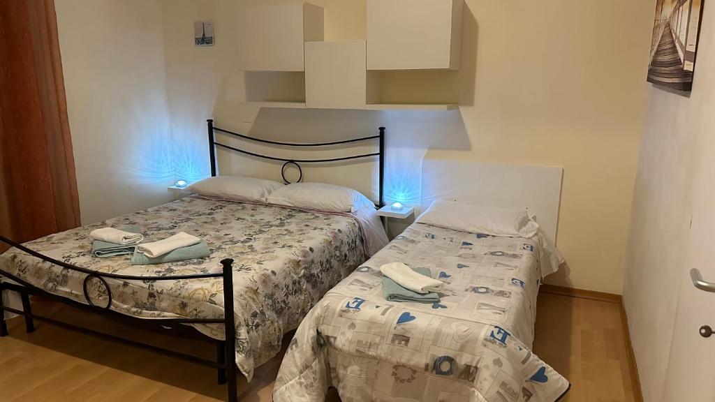 罗马CASA GEMELLI GEMELLI的小房间设有两张床,配有蓝色的灯光