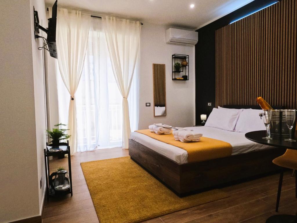 那不勒斯BlackWoody Contemporary Rooms - Napoli Centro Storico的一间卧室配有一张床、一张桌子和一个窗户。