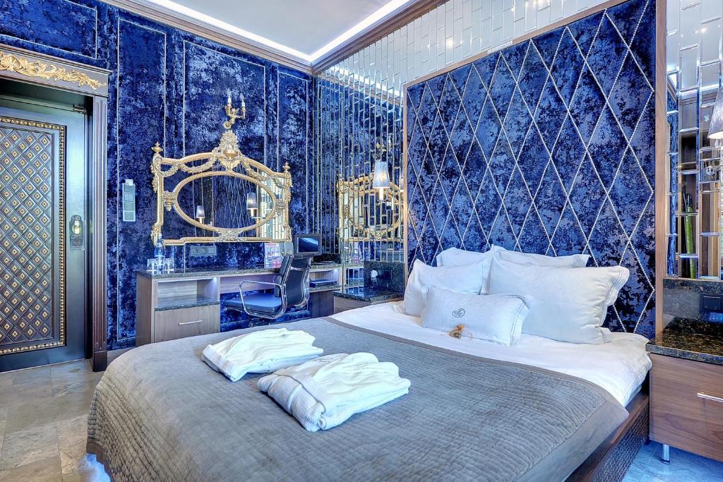 索波特Mała Anglia Deluxe Rooms & SPA的一间卧室配有一张带蓝色壁纸的大床