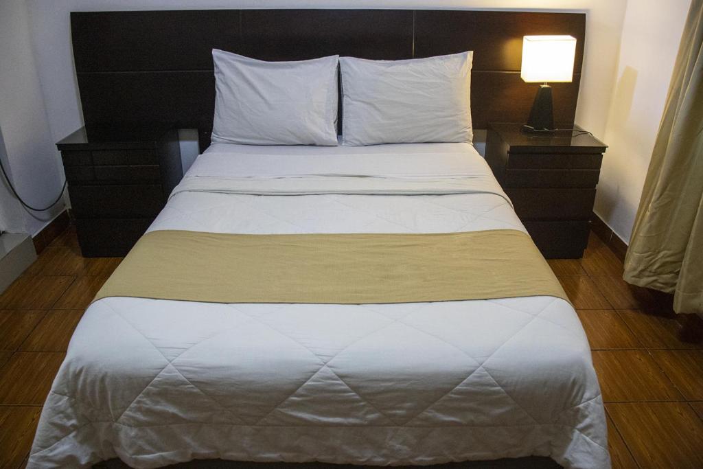 利马利马马约尔广场酒店的一张位于酒店客房内的床铺,配有白色床罩
