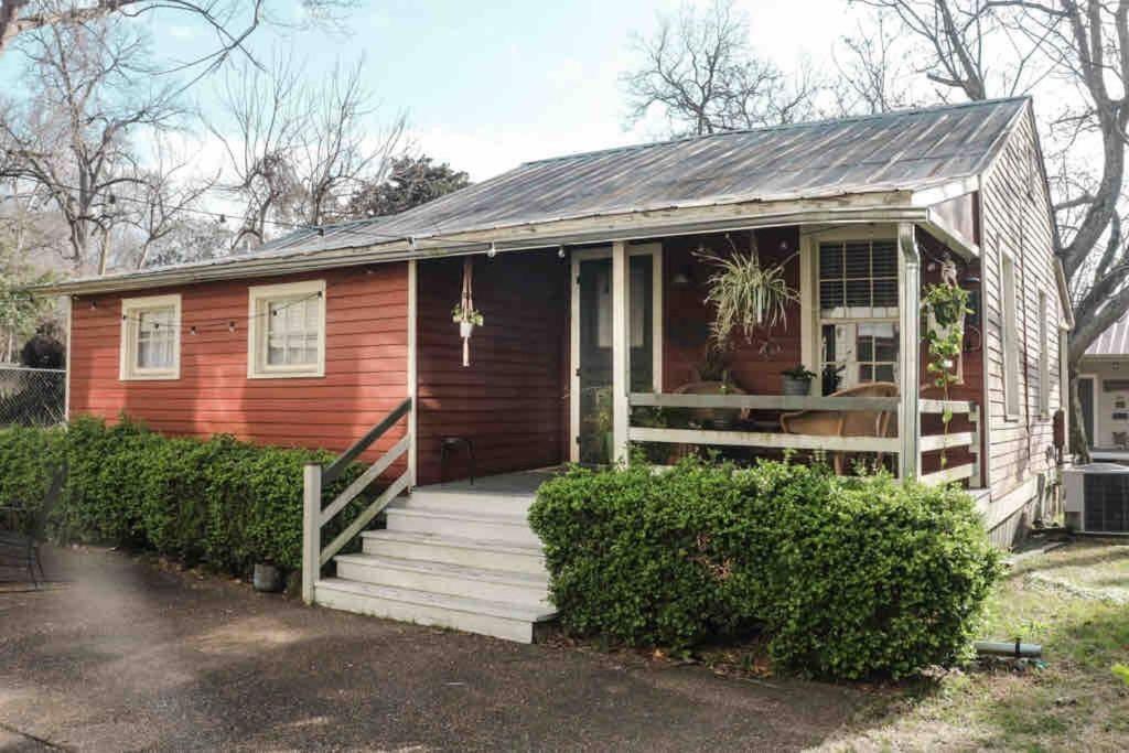 纳奇兹Wensel Cottage in downtown Natchez的一座红色的小房子,设有门廊和楼梯