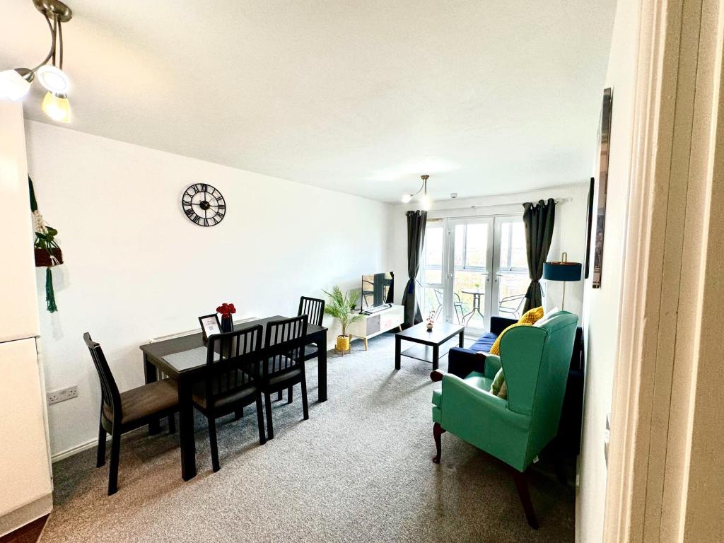 斯劳Bright & Spacious Flat - Perfect for Exploring London , Slough & Windsor!的客厅配有桌子和绿色椅子