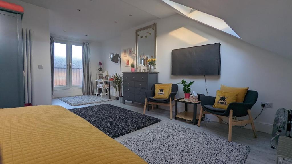 泰恩河畔纽卡斯尔Sidney Grove B&B的一间卧室配有黄色的床和一台平面电视