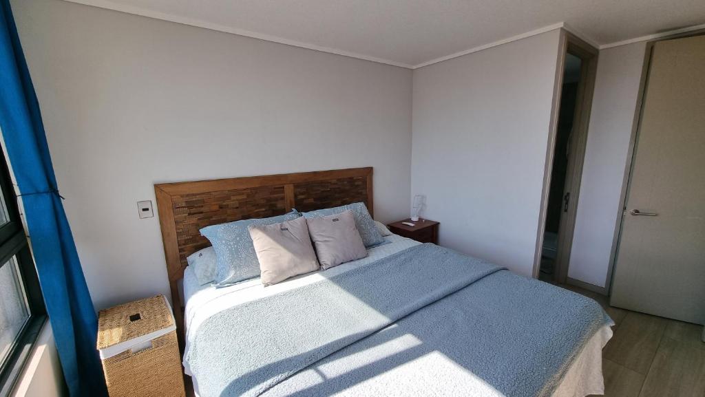 圣地亚哥SAN CRISTOBAL的一间卧室配有一张带蓝色床单和枕头的床。