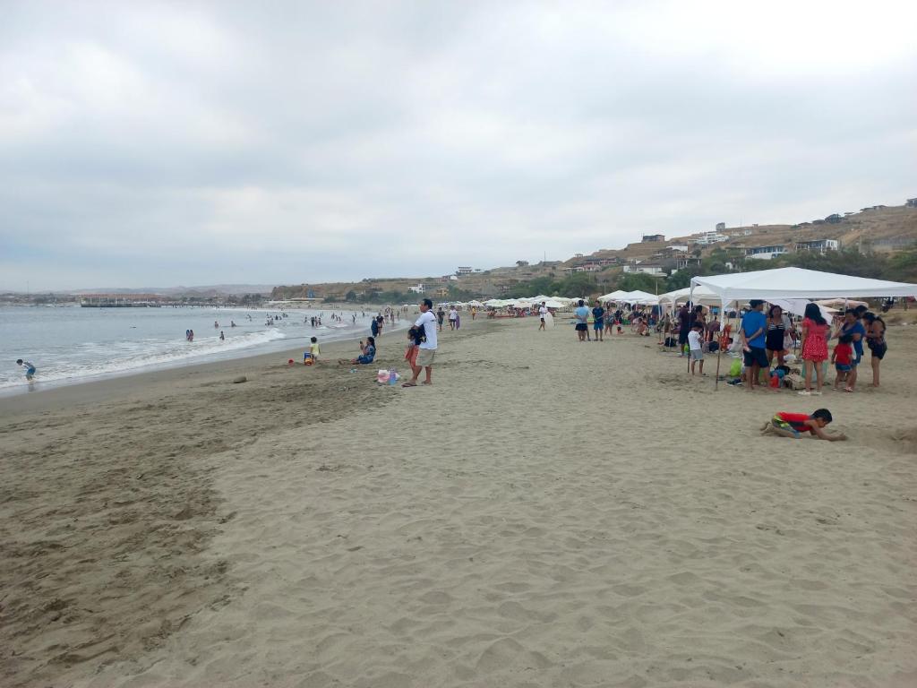 洛斯拉甘斯Casa Entre Rocas y Veleros的一群站在海滩上的人