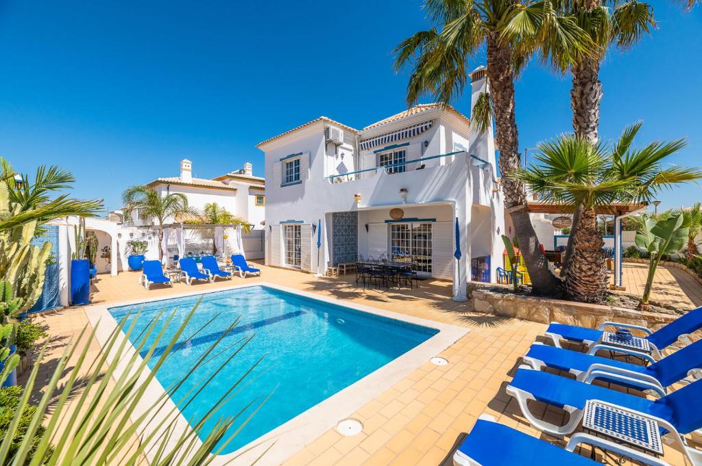阿尔布费拉Villa Oasis Galé - Luxury Villa with private pool, AC, free wifi, 5 min from the beach的一座别墅,设有游泳池和棕榈树
