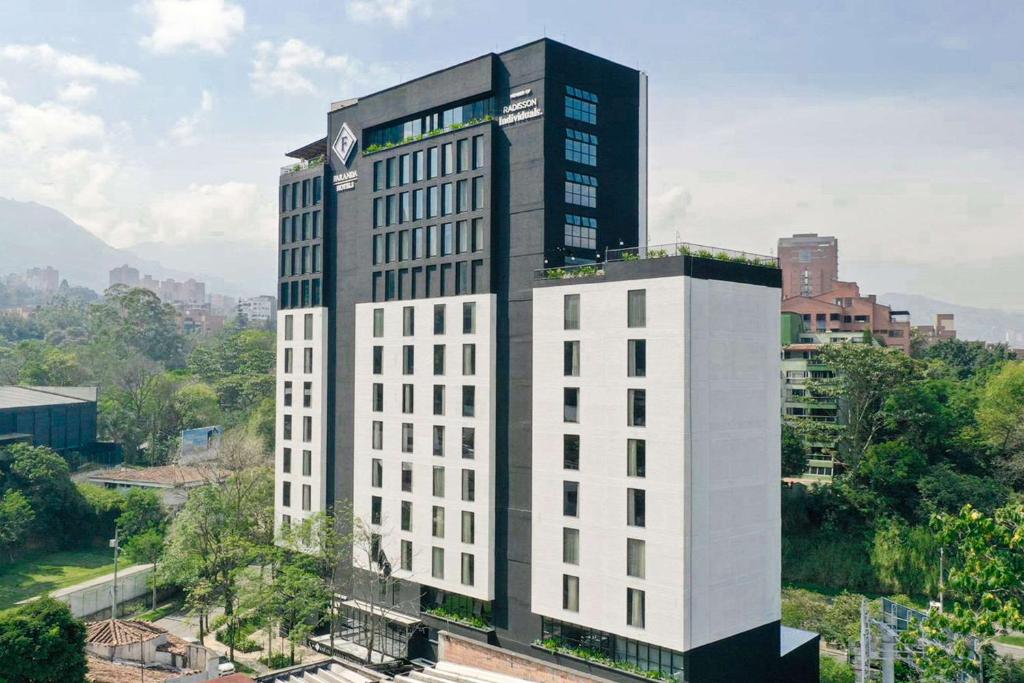 麦德林Faranda Collection Medellin, a Member of Radisson Individuals的一座高大的白色建筑,上面有钟