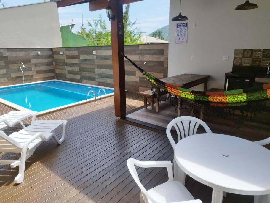 邦比尼亚斯Casa com piscina em Zimbros的一个带吊床的庭院和一个游泳池