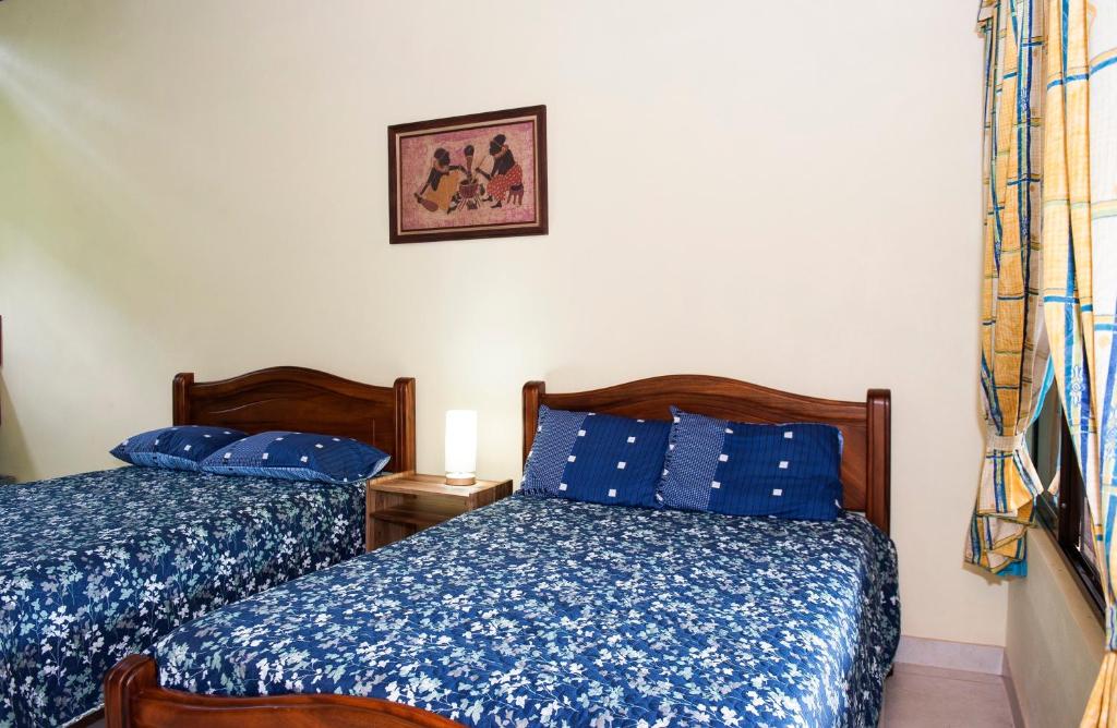 别霍港Hotel Sunshine Caribe的卧室配有两张床,墙上挂着一幅画
