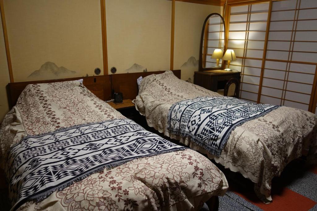 佐渡市Natural Mind Tour - Vacation STAY 94017v的两张睡床彼此相邻,位于一个房间里