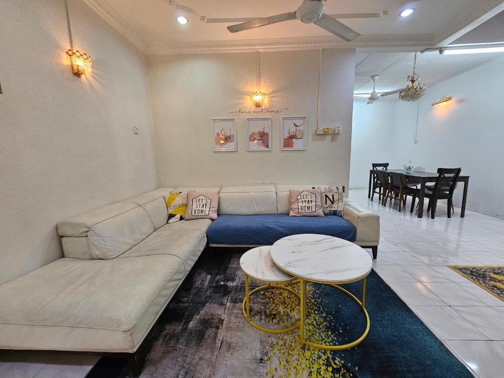 哥打巴鲁Ruhani Homestay 3 KB - 4 Bedroom Fully Airconditioned with WIFI & Netflix的客厅配有沙发和桌子