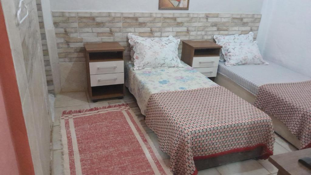 卡希亚斯公爵城Meu Quarto no Rio de Janeiro的一间卧室设有两张床和两个床头柜