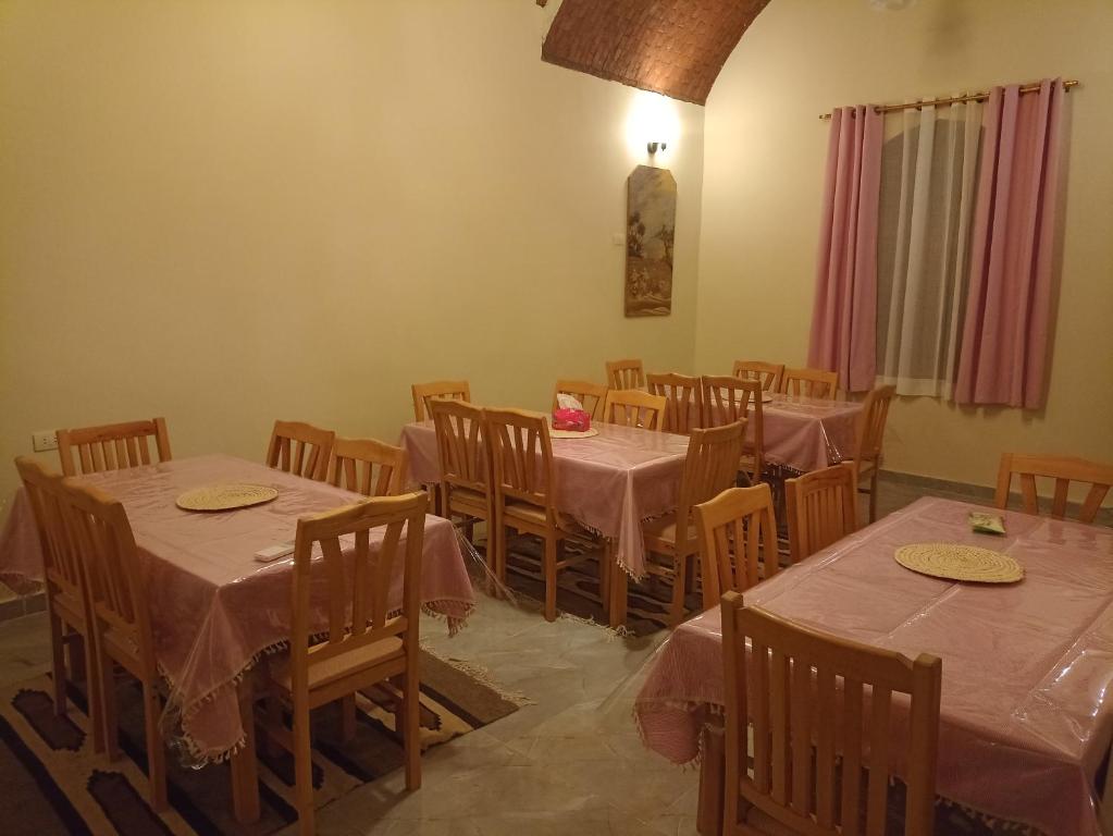 Qasr Al FarafirahRahala Safari Hotel的用餐室配有桌椅和粉红色的桌布