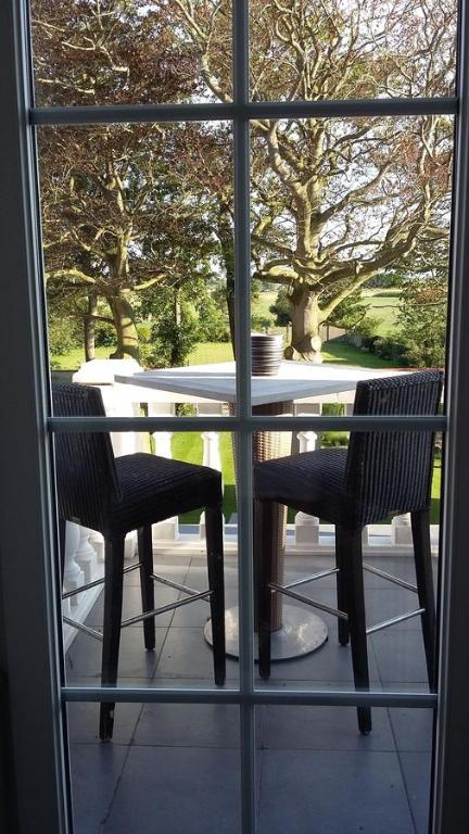 LeffingeLe Petit Chateau Vaartdijk的透过窗户可欣赏到桌椅的景色