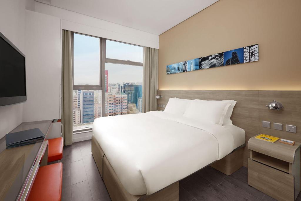 香港Lodgewood by Nina Hospitality Mong Kok的一间酒店客房,设有一张大床和一个大窗户