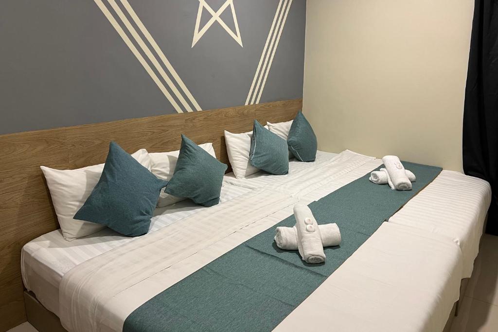 关丹KUANTAN BESERAH BUDGET HOTEL的一张大床,配有枕头和毛巾