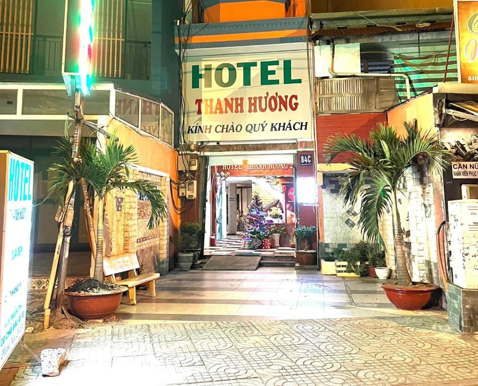 胡志明市Thanh Hương Hotel的楼内带有棕榈树的酒店走廊