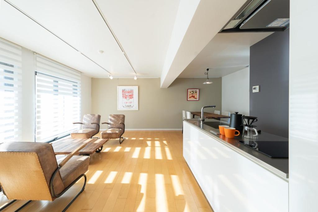 东京コートヤード広尾的一间带椅子的客厅和一间带柜台的厨房