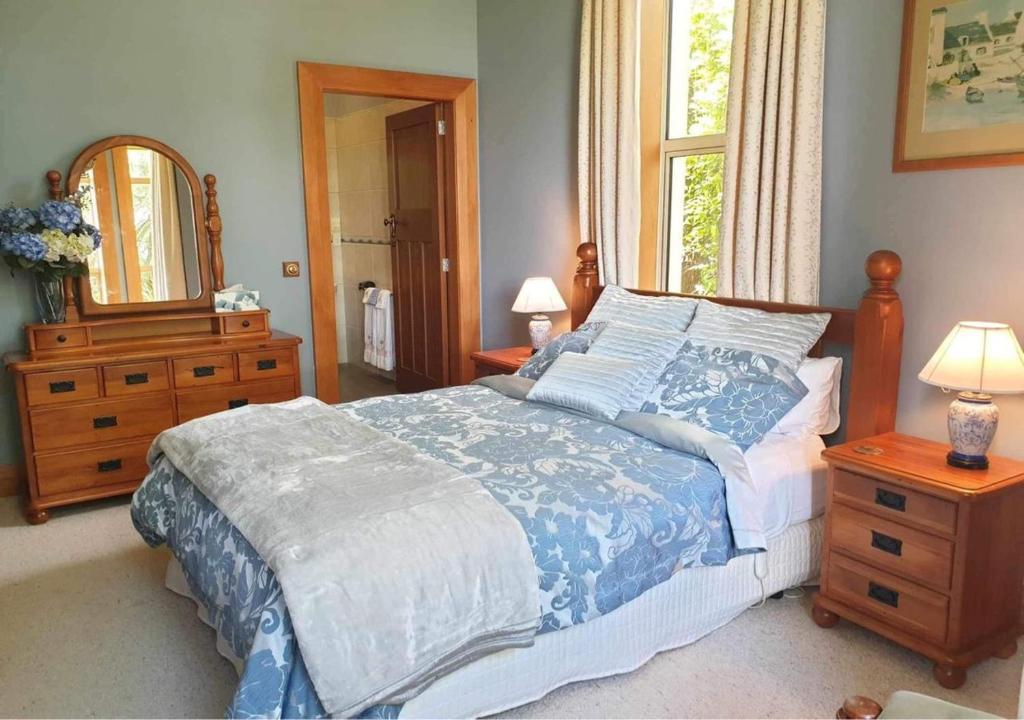 WintonBelvedere Bed & Breakfast的一间卧室配有一张床、梳妆台和镜子