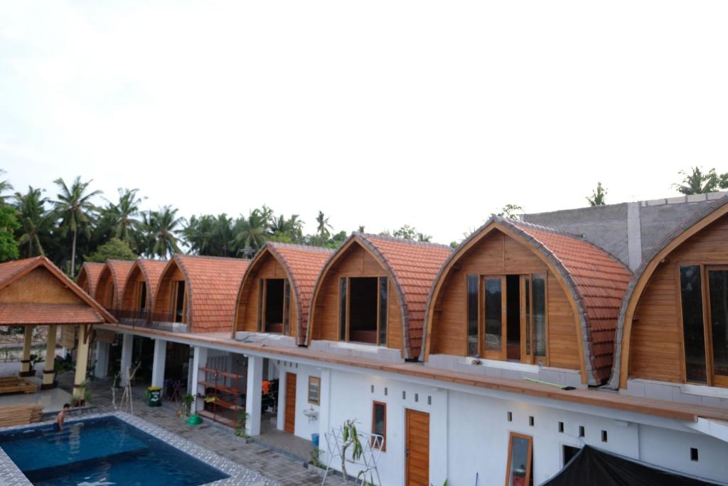 珀尼达岛Garuda Hostel & Accomodation Nusa Penida的木屋顶房屋的图象
