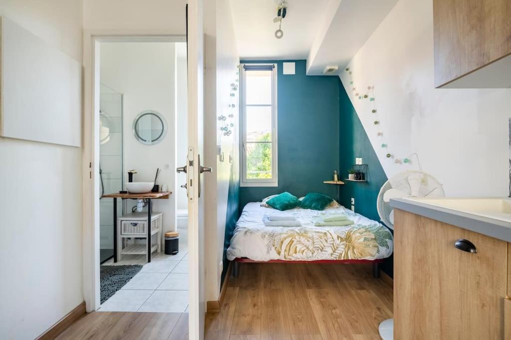 贝尔热拉克Le Vin Quatre的一间卧室设有蓝色的墙壁、一张床和一个水槽