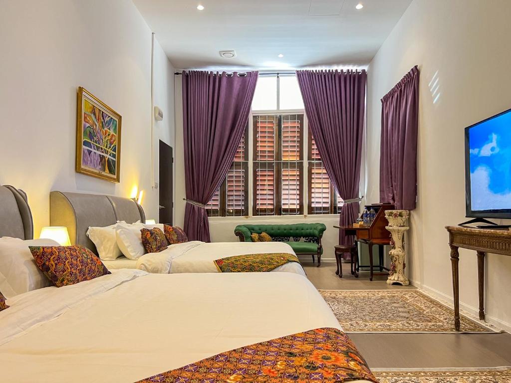 乔治市Peranakan Suites Georgetown的酒店客房设有两张床和一台平面电视。