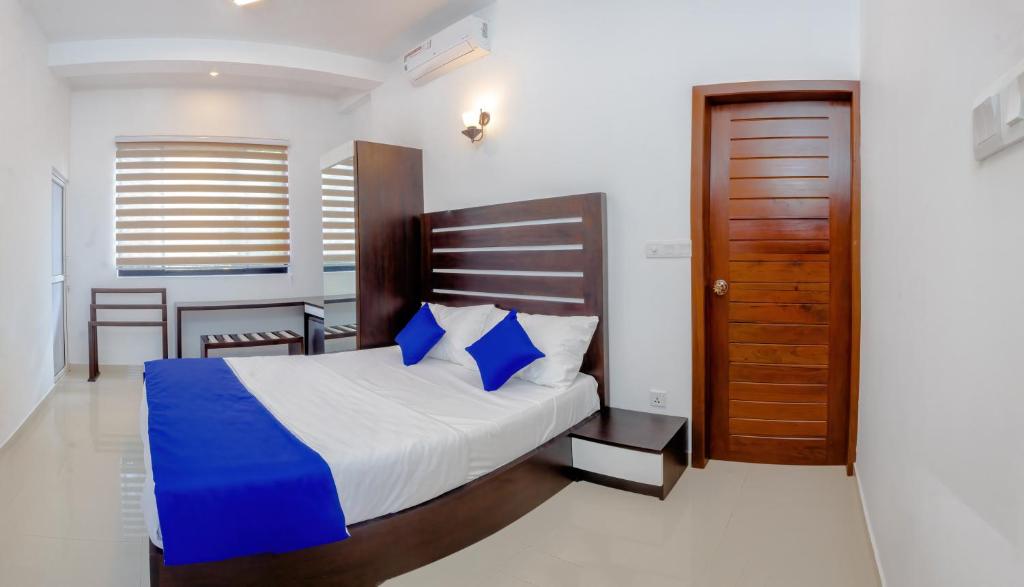 尼甘布Ceylanro Transit Villa的一间卧室配有一张床和一扇木门