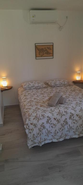 阿瓦托鲁Bungalow Kahaia Lodge的卧室内的一张床位,配有两盏灯和床罩
