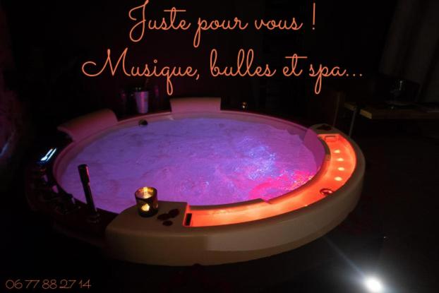 MédisLOVE Suites & SPA "Le Chai" avec lit rond的紫色客房内的按摩浴缸