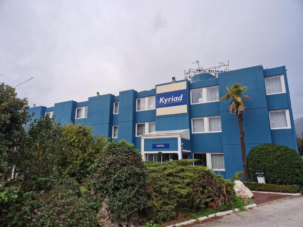 拉加尔德Kyriad Toulon Est Hyeres La Garde的蓝色的酒店,前面有棕榈树