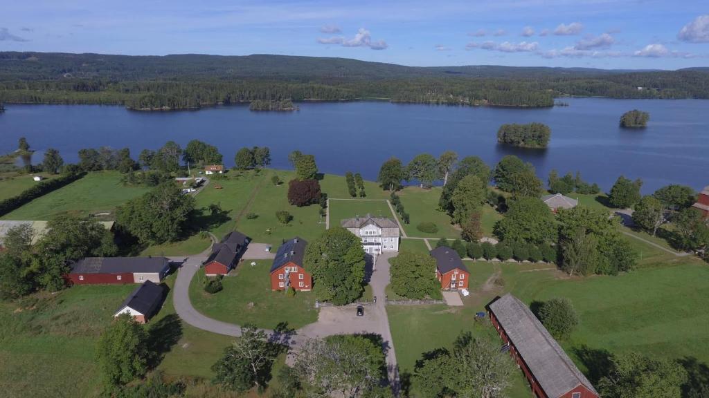 SvanskogSvaneholm Hotel的享有湖畔房屋的空中景致