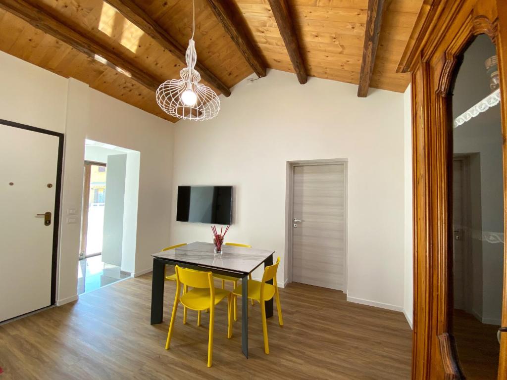 法诺Levante Flat - 100 m from the beach的一间用餐室,配有一张黑桌子和黄色椅子