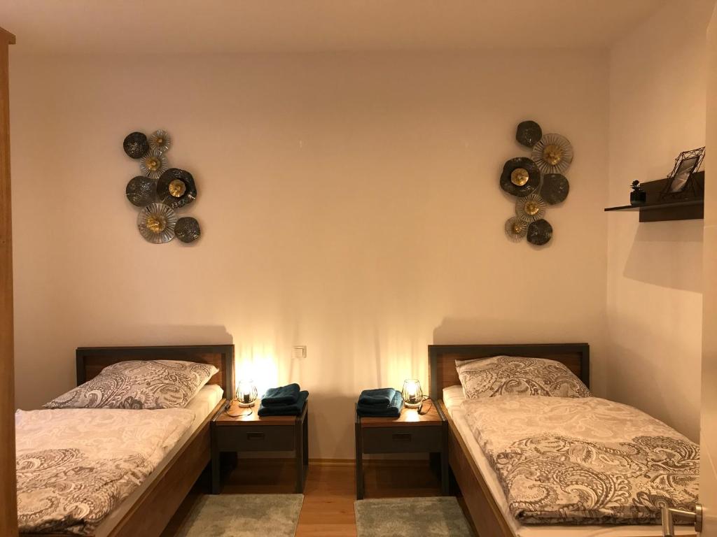 茨维考Mimalou Apartment in Zwickau的配有两张床铺的房间,墙上挂有两盏灯和鼓