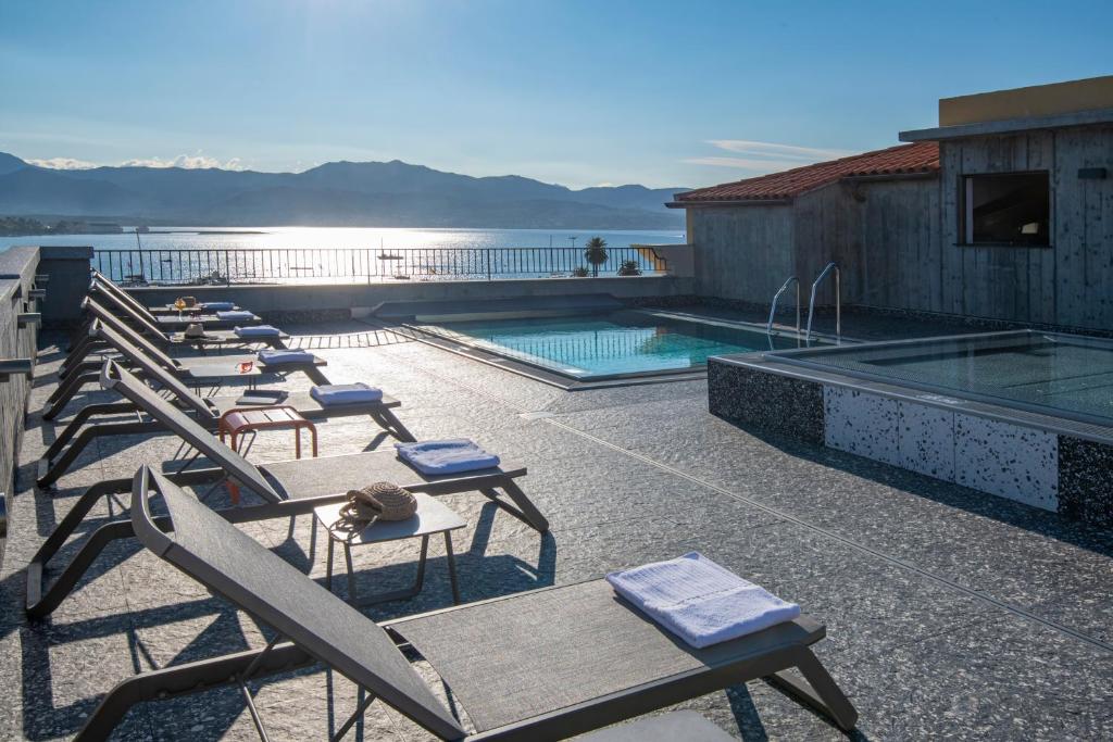 阿雅克修ibis Styles Ajaccio Napoleon的大楼里一排椅子和一个游泳池