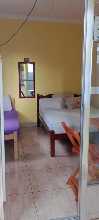 佩尼多Alta Vista的一间卧室配有一张床、一把椅子和镜子
