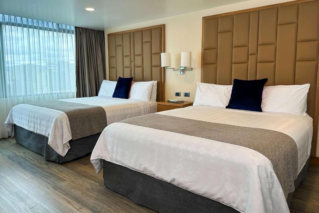 基多基多温德姆花园酒店的酒店客房设有两张床和窗户。
