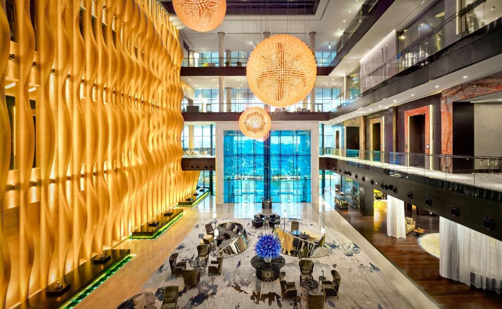 阿布扎比Grand Hyatt Abu Dhabi Hotel & Residences Emirates Pearl的大型大堂设有桌椅和灯